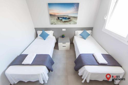 twee bedden in een kamer met uitzicht op het strand bij Roses Apartments Ocean 2 habitaciones vista mar lateral in Roses