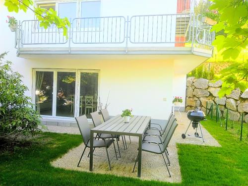 a wooden table and chairs in a yard at Romantic Style Apartment Titisee-Neustadt in Titisee-Neustadt