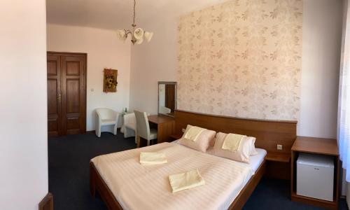 チェスキー・クルムロフにあるペンション ファルコのベッド、テーブル、椅子が備わるホテルルームです。