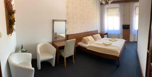 a bedroom with a bed and a table and chairs at Pension Falko in Český Krumlov