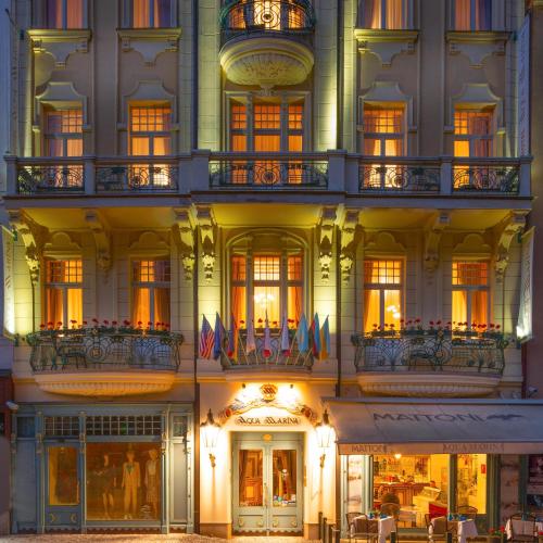 a lit up building with flags on the balconies at Aqua Marina in Karlovy Vary