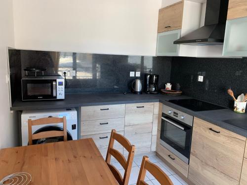 une cuisine avec une table et des chaises et un micro-ondes dans l'établissement Belle Rade Les pieds dans l'eau, à Dunkerque