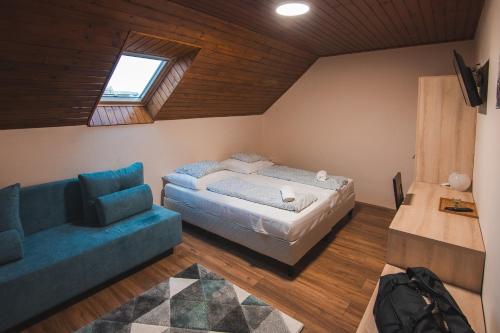 a bedroom with a bed and a couch at Natúra Panzió&Apartmanház in Orfű