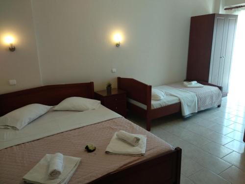 a bedroom with two beds with towels on them at Nick Rooms in Stavros