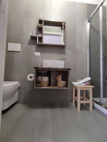 een badkamer met een wastafel, een toilet en een spiegel bij Civico10 Polignano in Polignano a Mare