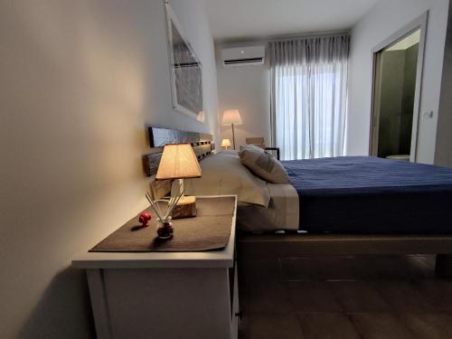 een slaapkamer met een bed en een tafel met een lamp bij Civico10 Polignano in Polignano a Mare
