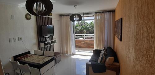sala de estar con sofá, mesa y TV en Apartamento em Resort en Barreirinhas