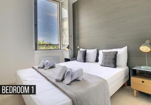 une chambre avec un grand lit blanc avec une fenêtre dans l'établissement Nestor&Jeeves - ALBERT 1ER DESIGN - Hyper center - Very close sea and pedestrian zone, à Nice