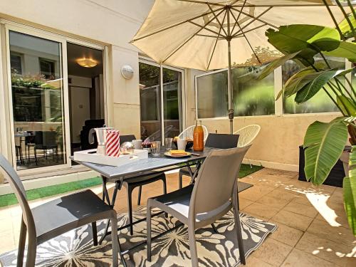 une table et des chaises avec un parasol sur une terrasse dans l'établissement Nestor&Jeeves - BERLIOZ PATIO - Central - Residential area - Patio 20m, à Nice