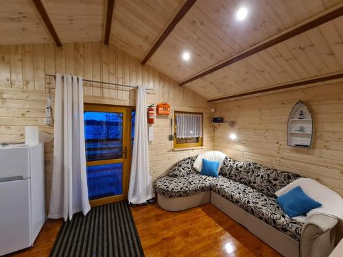 ein Wohnzimmer mit einem Sofa in einer Hütte in der Unterkunft Siedlisko nr 4A nad jeziorem Skarlińskim, jezioro, mazury, domki letniskowe in Kurzętnik