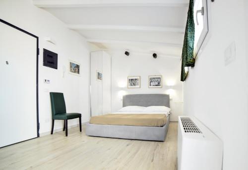 a white bedroom with a bed and a chair at 55 Florence in Florence