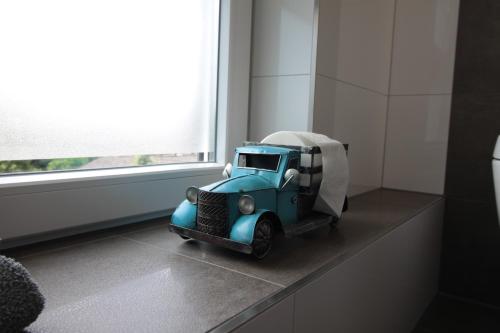a blue toy truck sitting on a ledge next to a window at Apartment Meine in Meine