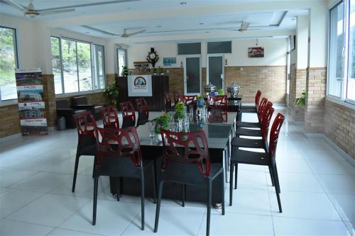 a dining room with a table and red chairs at Cedar Vista Resort in Kāgān