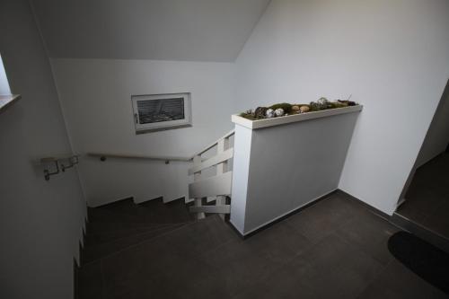 a hallway with stairs with a plant on the wall at Apartment Meine in Meine