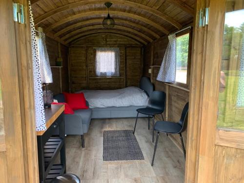 una camera da letto in una casetta con un letto e sedie di Pipowagen Het Kasteel a Diever