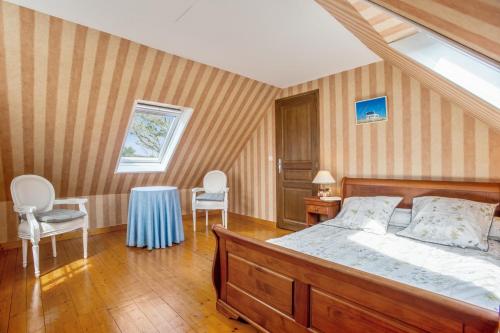 une chambre avec un lit, deux chaises et une table dans l'établissement Maison de charme à Bangor avec grand jardin clos, à Bangor