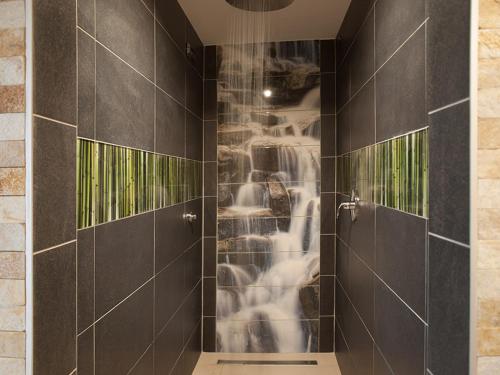 a bathroom with a shower with black tiles at Penzion Malina in Hronská Dúbrava