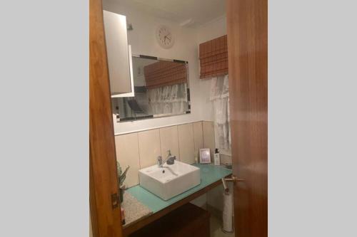 a bathroom with a sink and a mirror at Cozy self-contained unit surrounded by nature in Goonellabah