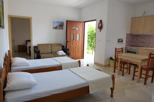 a living room with two beds and a kitchen at Pellumb Apartments in Ksamil