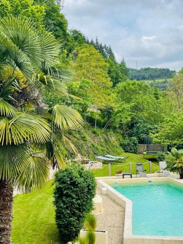 une image d'une piscine dans un jardin dans l'établissement Les Gîtes du Moulin d Olt, à La Canourgue