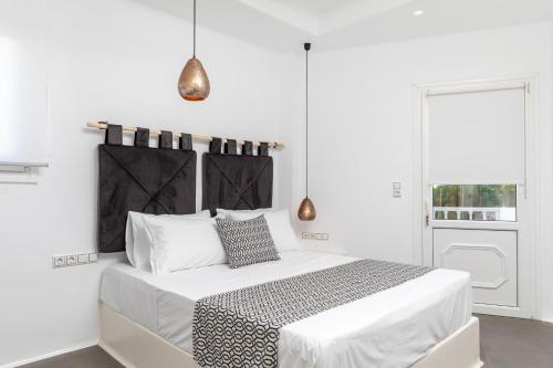 een witte slaapkamer met een groot bed en een raam bij Naxos DownTown Apartments & Suites in Naxos Chora