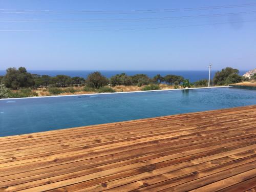 a large swimming pool with a wooden deck at Beso Patara in Patara