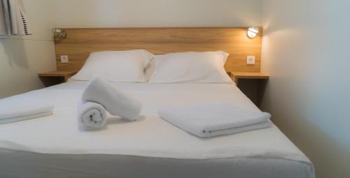 a white bed with white sheets and pillows at HILLS RESORT Beach, Bungalows and Bar - Velika Plaza Ulcinj in Ulcinj