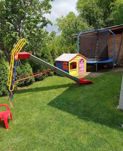 a playground with a slide in the grass at Семейна къща Лазарови in Sapareva Banya