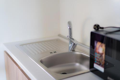 a sink in a kitchen with a microwave next to it at HILLS RESORT Beach, Bungalows and Bar - Velika Plaza Ulcinj in Ulcinj