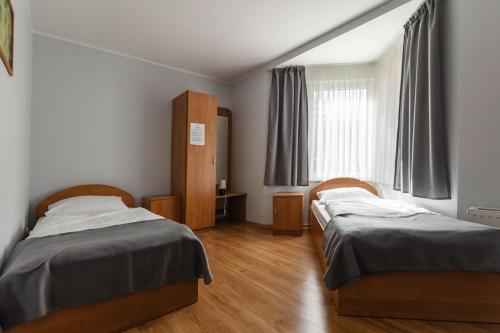 イェレニャ・グラにあるWilla Sobieszówのベッド2台と窓が備わる客室です。