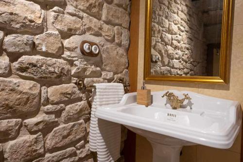 a bathroom with a sink and a stone wall at Ca la Cinta de Maldà in Maldá