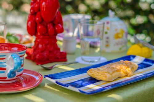 a table with a blue plate with a piece of food at Villa Iolanda in Piano di Sorrento