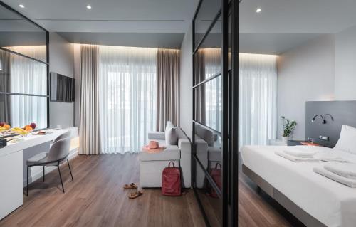 a bedroom with a white bed and a desk and a table at Ivis 4 Boutique Hotel in Athens