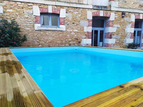 a swimming pool in front of a building at L'Ancienne Boulangerie in Chavagnes