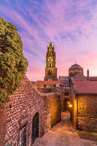 a building with a clock tower in the background at Garage, 2 chambres, balnéo, 2 SDB, 2WC, vue sur les monuments in Le Puy en Velay
