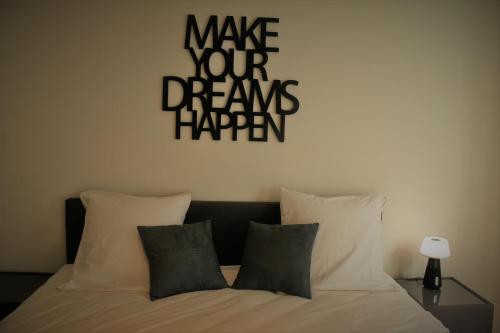 Un dormitorio con una cama con un cartel que dice "Haz realidad tus sueños". en Salt&Sea, en Middelkerke
