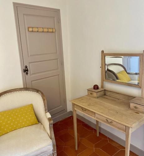 a room with a mirror and a chair and a table at Domaine Les Mûriers in Brignoles
