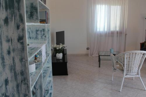 a living room with a chair and a book shelf at La casa del Sole in Fermo