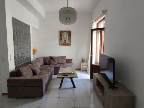 a living room with a couch and a tv at Dr. J. Spon Apartment in Nafpaktos