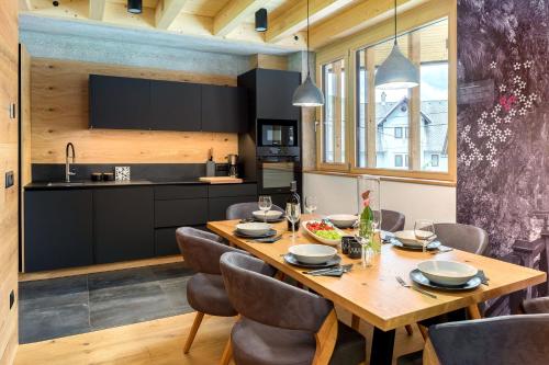 a kitchen and dining room with a wooden table and chairs at Hiša Križaj in Bohinj