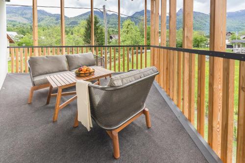 a balcony with a table and two chairs and a table at Hiša Križaj in Bohinj