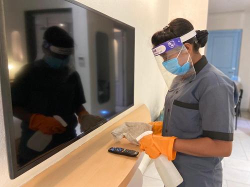 a man wearing a face mask and goggles in front of a mirror at Ramee Royal Resort & Spa - Udaipur in Udaipur