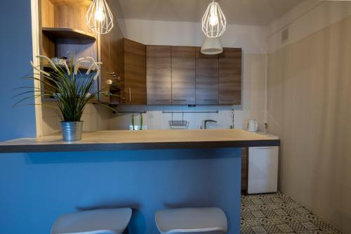 a kitchen with a blue counter and wooden cabinets at Apartament Eliza in Warsaw