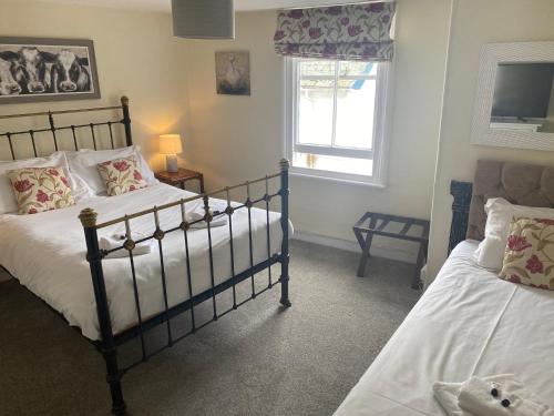 a bedroom with two beds and a window at The Ship Inn Fowey in Fowey