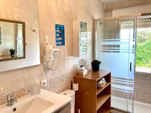 y baño con lavabo, ducha y aseo. en Casa Rural Aventura I, en Navaluenga