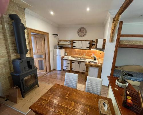a kitchen with a wood stove and a table at Apartmán Sarah Noemi, 100 m SKIBUS JASNA in Liptovský Mikuláš