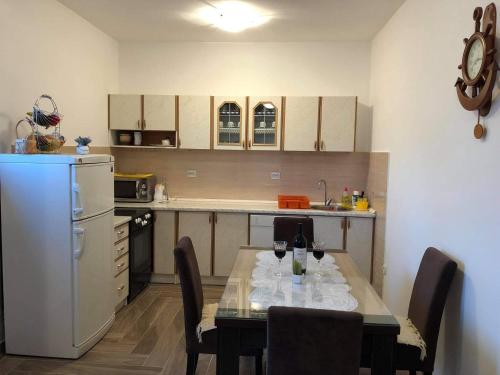 - une cuisine avec une table et des verres à vin dans l'établissement Apartman Čičković, à Bijela