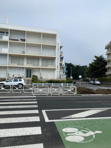 un estacionamiento con un coche estacionado frente a un edificio en LA RESIDENCE, en La Baule