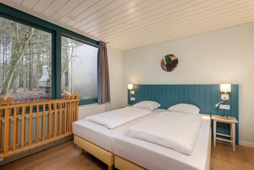 a bedroom with a large bed and a window at Center Parcs Heijderbos Limburg-Weeze in Heijen