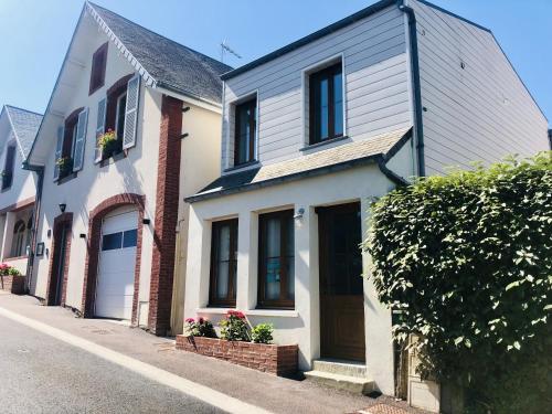 a white house on a street next to houses at La Cabine De La Baie in Saint-Pair-sur-Mer